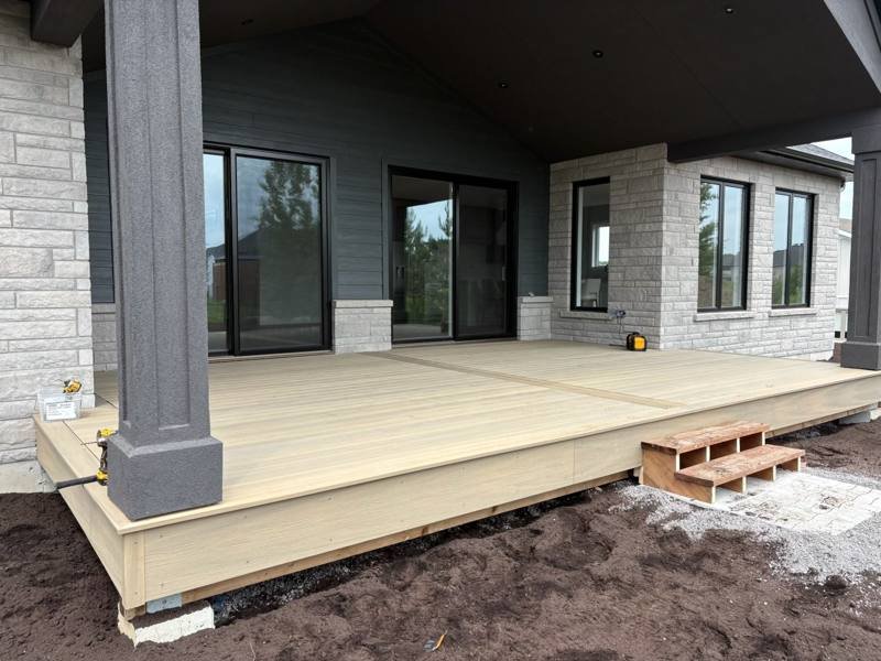 Covered composite deck with stone columns on a new home
