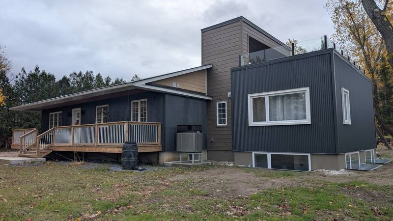 Modern home finished in dark vertical steel cladding