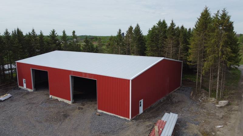 Red steel-clad shop with a new white metal roof