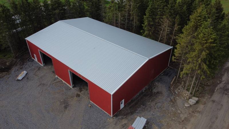 Red steel-clad shop with a new white metal roof