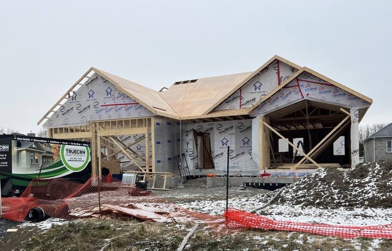 TrueCon site trailer beside a custom home being framed