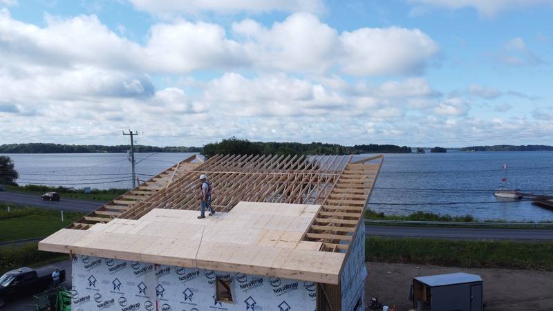 Roof deck and rafters on a waterfront custom home, with the river behind